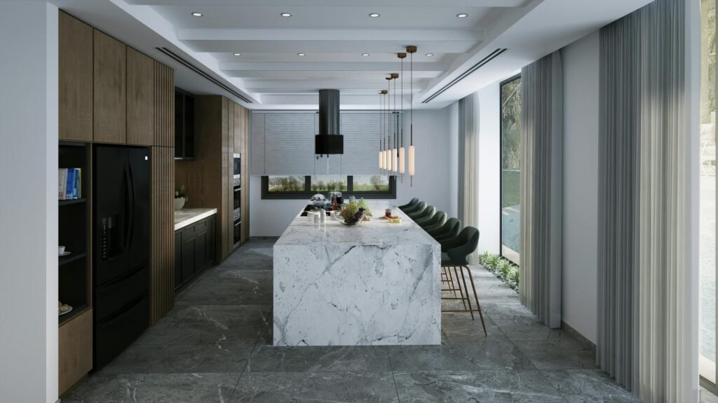 Spacious modern kitchen featuring a marble island, pendant lights, and natural light.